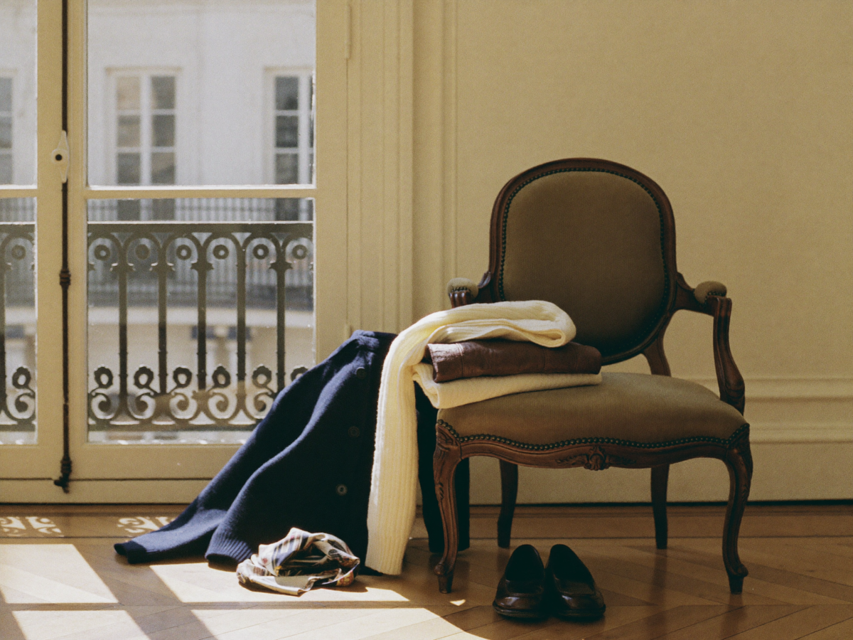 Vauclaire Paris - pull torsadé crème et manteau marine sur fauteuil, appartement parisien
